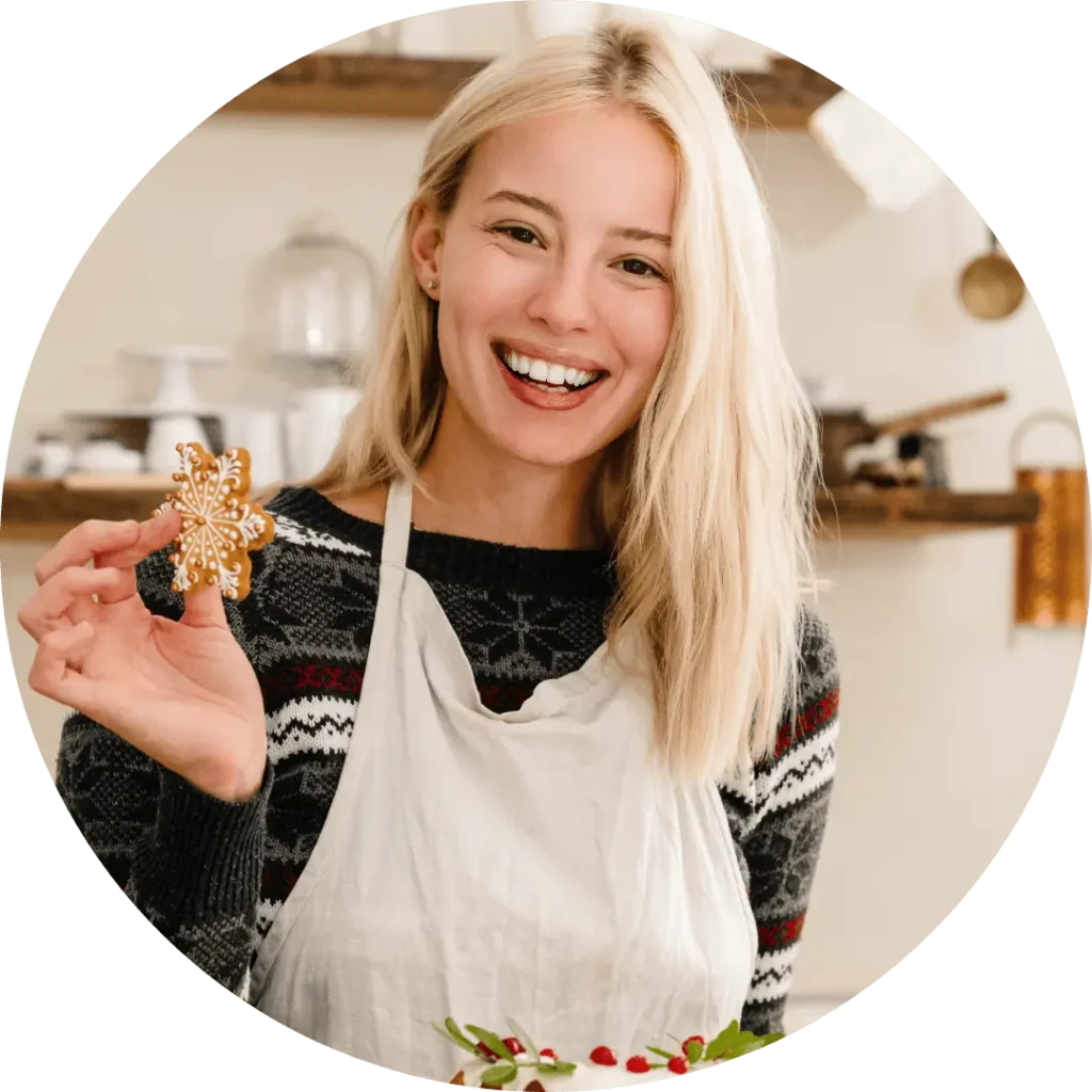 Elena Janice cooking in a Mediterranean kitchen, smiling and holding a dessert