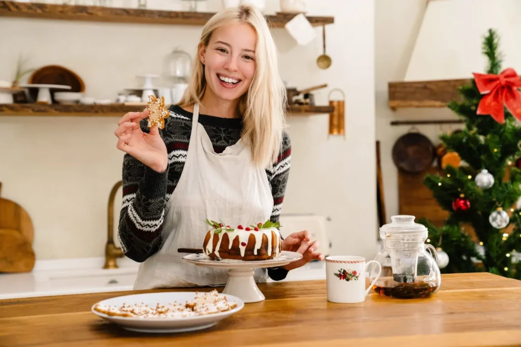 Elena Janice cooking in a Mediterranean kitchen, smiling and holding a dessert